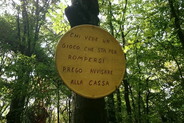 Cartello di legno tondo scritto a mano appeso a un albero al parco Ai Pioppi