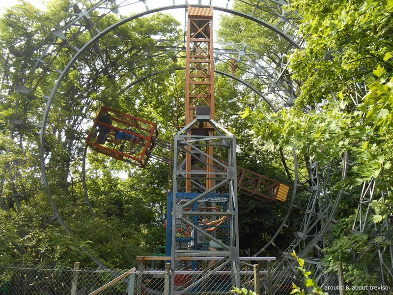 Handmade metal and wood ride at the Ai Pioppi amusement park, surrounded by greenery