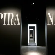 Ingresso buio di una mostra su Piranesi con grandi scritte sulle pareti