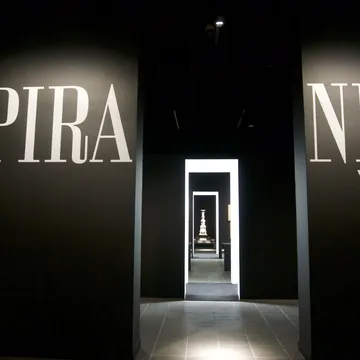 Ingresso buio di una mostra su Piranesi con grandi scritte sulle pareti