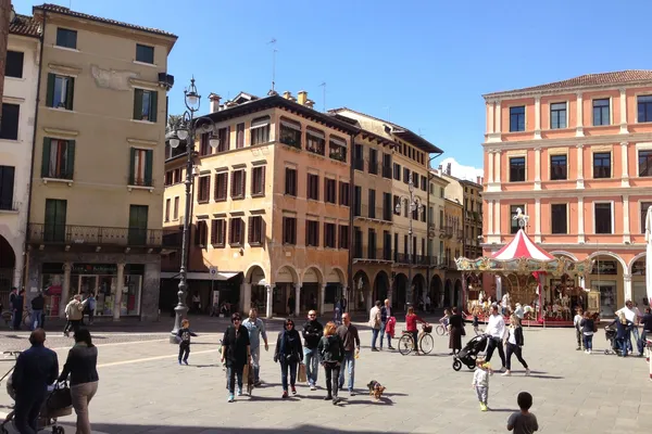 Piazza dei Signori a Treviso con palazzi storici, portici e una giostra