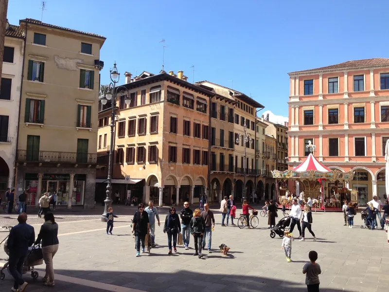 Piazza dei Signori in Treviso with historic buildings, arcades and a carousel