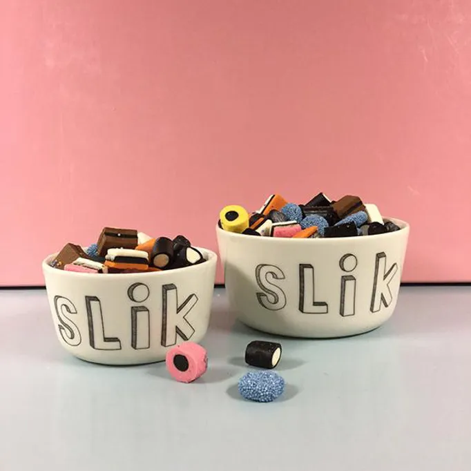 Due ciotole con scritta Slik piene di caramelle assortite