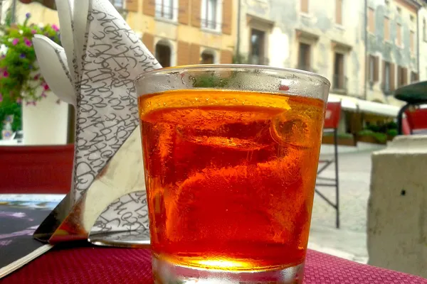 Bicchiere di Spritz veneto arancione su un tavolino in una piazza