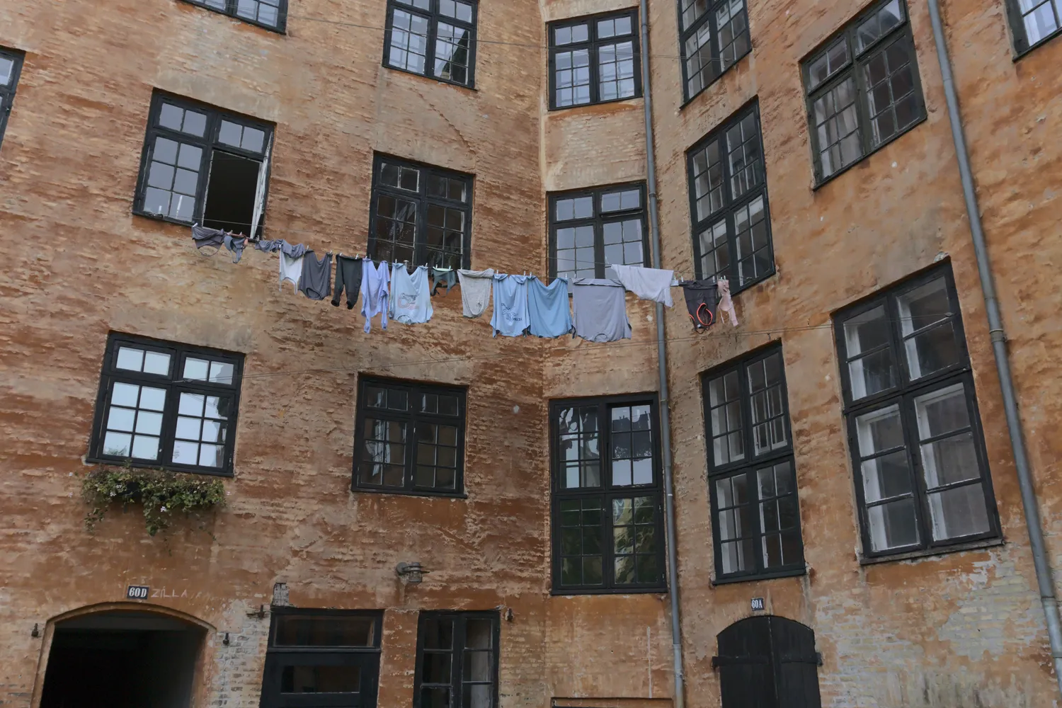 Bucato steso tra le finestre nel cortile di un edificio in mattoni a Christianshavn