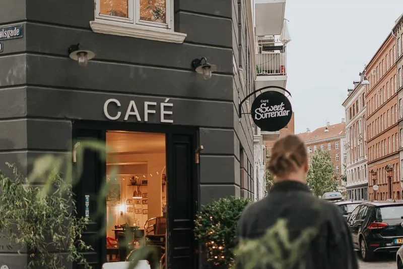 Il Café Sweet Surrender, caffè d'angolo con insegna nera a Copenaghen