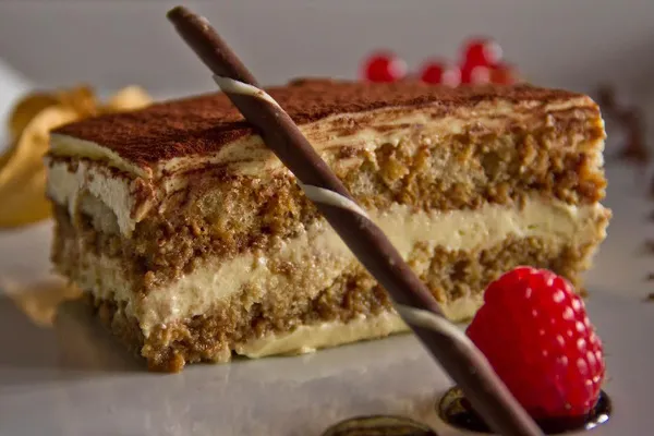 Fetta di tiramisù con cialda di cioccolato e lampone fresco