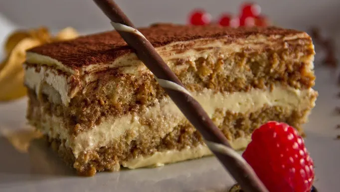 Fetta di tiramisù con cialda di cioccolato e lampone fresco