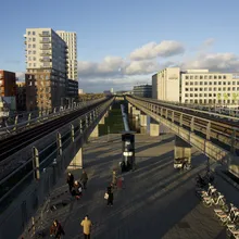 Stazione del metro sopraelevata con binari e palazzi moderni a Ørestad
