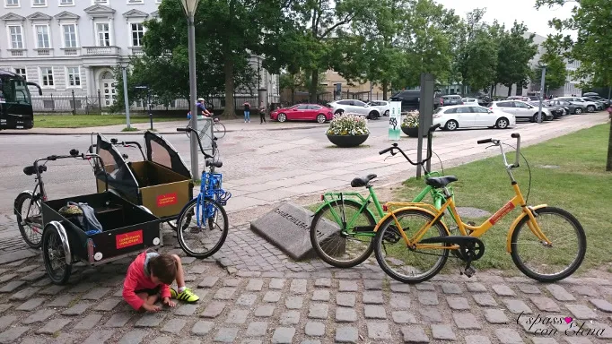 Colourful bicycles and a cargo bike parked on a cobbled Copenhagen square