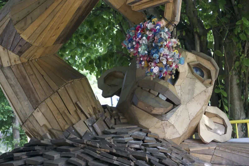 Volto del troll gigante Sutte Sanka in legno con corona di fiori