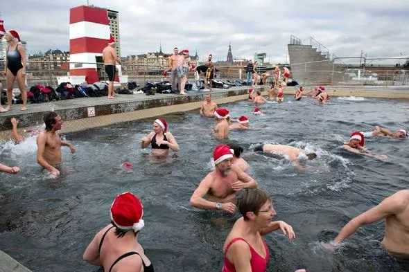 Bagnanti con cappelli di Babbo Natale fanno il bagno invernale a Copenaghen