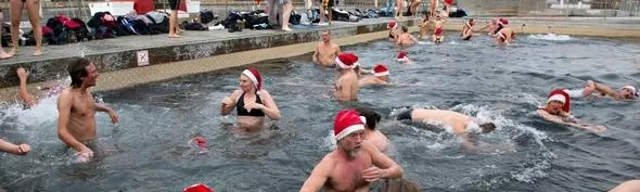 Bagnanti con cappelli di Babbo Natale fanno il bagno invernale a Copenaghen