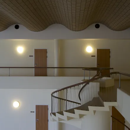Atrio del Terminal Vilhelm Lauritzen con scala elicoidale e soffitto ondulato in legno