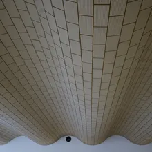 Soffitto curvo rivestito di piastrelle chiare con disegno a raggiera