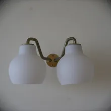 Applique da parete a due luci con paralumi bianchi e braccio in ottone