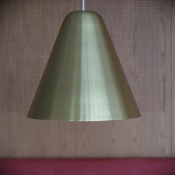 Lampada a sospensione conica in ottone davanti a parete in legno